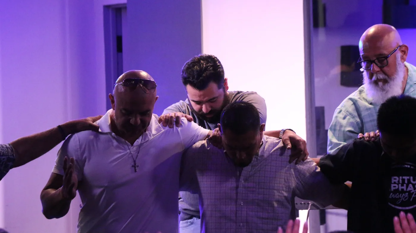 Men of Hope praying together during a church gathering